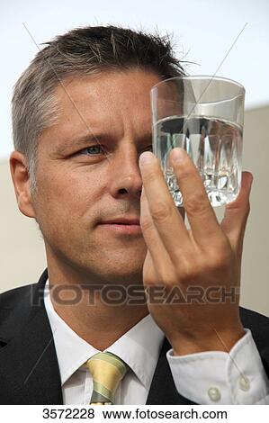 Businessman holding glass of water View Large Photo Image Stock Photo - Businessman holding glass of water . Fotosearch