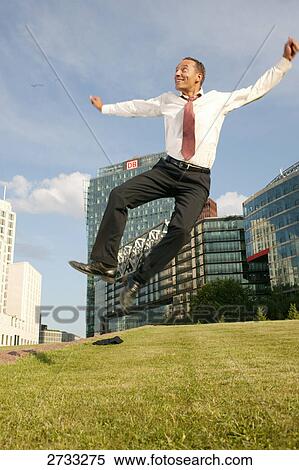Stock Photography - Businessman jumping midair in jubilation, Potsdamer Platz, Berlin, Germany . Fotosearch