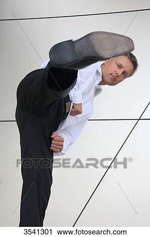 Stock Image - Businessman kicking with his foot . Fotosearch