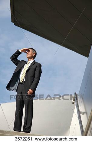 Businessman outdoors looking up View Large Photo Image Stock Image - Businessman outdoors looking up . Fotosearch