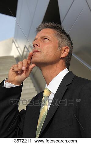 Stock Image - Businessman outdoors thinking . Fotosearch