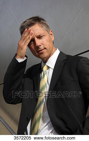 Businessman outdoors with hand on his forehead View Large Photo Image Stock Photography - Businessman outdoors with hand on his forehead . Fotosearch