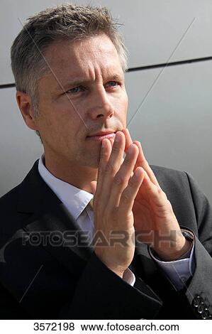 Stock Photo - Businessman outdoors with hands folded . Fotosearch