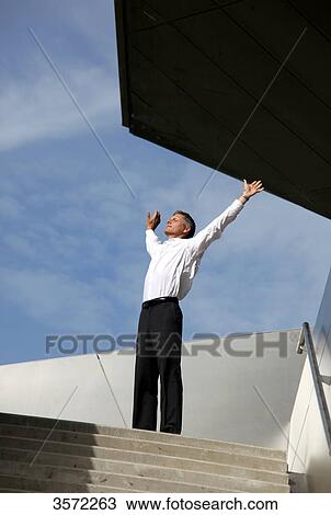 Businessman raising his arms outdoors View Large Photo Image Stock Image - Businessman raising his arms outdoors . Fotosearch