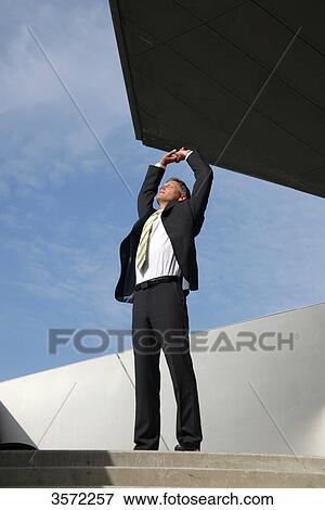 Businessman raising his arms outdoors View Large Photo Image Stock Photo - Businessman raising his arms outdoors . Fotosearch