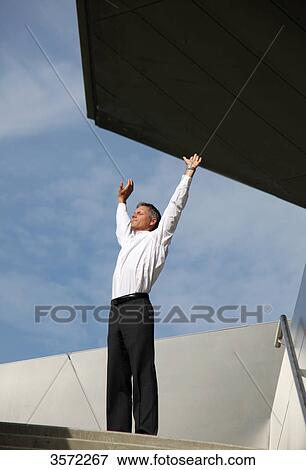 Stock Photo - Businessman raising his arms outdoors . Fotosearch