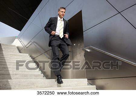 Stock Image - Businessman rushing down stairs . Fotosearch