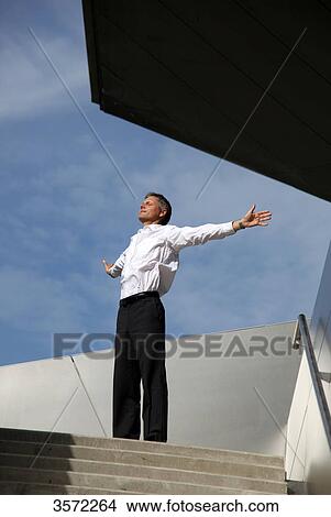Businessman spreading his arms outdoors View Large Photo Image Picture - Businessman spreading his arms outdoors . Fotosearch
