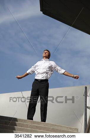 Stock Image - Businessman spreading his arms outdoors . Fotosearch
