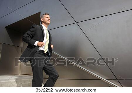 Stock Image - Businessman walking downstairs . Fotosearch