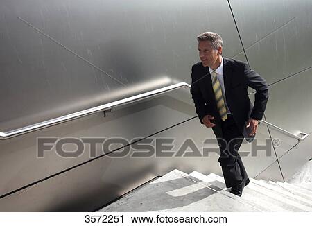Stock Image - Businessman walking upstairs . Fotosearch