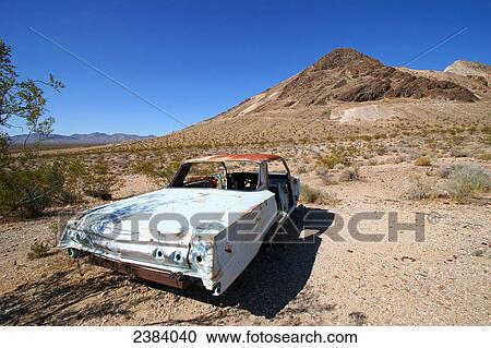 Stock Image - Car wreck on landscape, Nevada, USA . Fotosearch