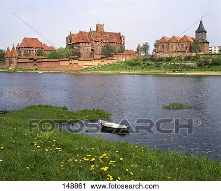 Stock Image - Castle at waterfront, Nogat River, Malbork Castle, Malbork, Poland . Fotosearch