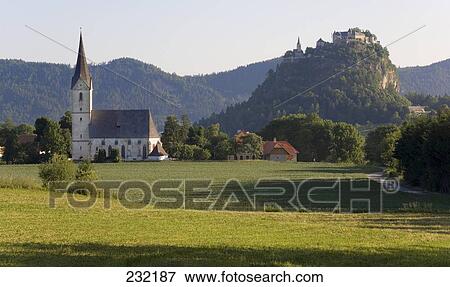 Stock Photo - Church with castle on hill in background, Hochosterwitz Castle, Carinthia, Austria . Fotosearch