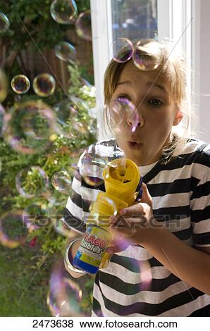 Close-up of girl blowing soap bubbles, England View Large Photo Image Stock Photo - Close-up of girl blowing soap bubbles, England . Fotosearch