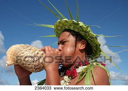 Stock Image - Close-up of man blowing sea shell, Makemo, Tuamotu Archipelago, French Polynesia, Polynesia, Pacific Island . Fotosearch