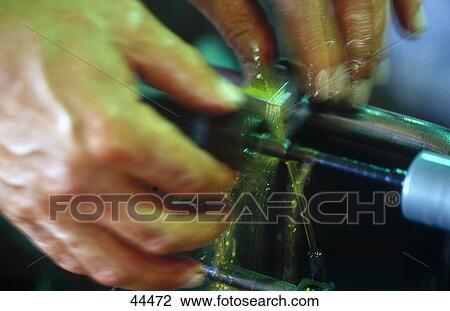 Stock Image - Close-up of man working on machine in craft industry . Fotosearch
