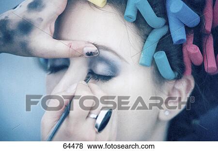 Close-up of person's hand applying eye shadow on young woman's eye View Large Photo Image Stock Photo - Close-up of person's hand applying eye shadow on young woman's eye . Fotosearch