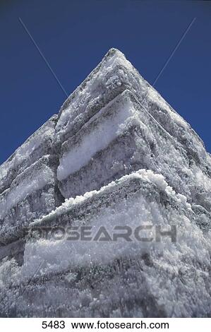 Stock Image - Close-up of salt piece against blue sky, Salar De Uyuni, Bolivia . Fotosearch
