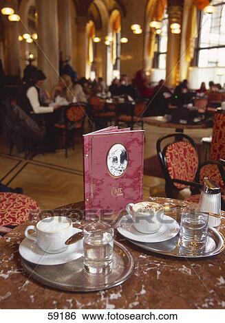 Stock Photograph - Coffee cups and glasses of water on table, Vienna, Austria, Europe . Fotosearch