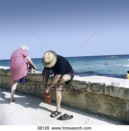 Stock Photo - Couple dressing up clothes on stone wall . Fotosearch