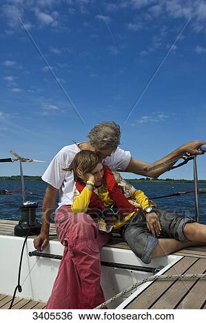 Father and son sitting on a sailing yacht View Large Photo Image Stock Photograph - Father and son sitting on a sailing yacht . Fotosearch