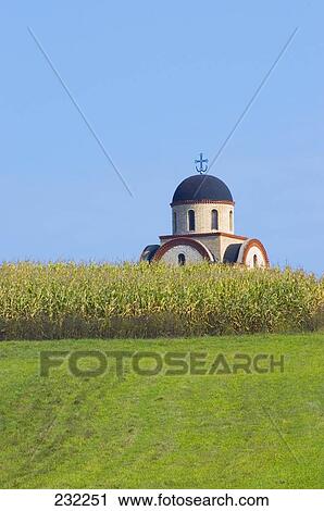 Stock Image - Field with church in background, Sandzak, Serbia . Fotosearch