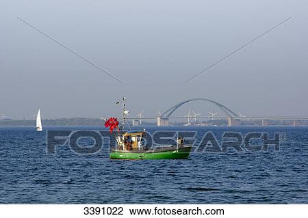 Stock Image - Fishing boat and Fehmarnsund bridge, Schleswig-Holstein, Germany . Fotosearch