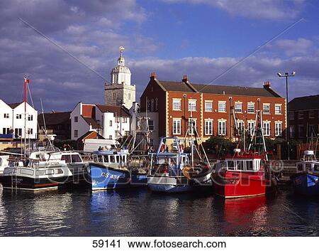 Stock Image - Fishing boats in front of cathedral, Hampshire, France, Europe . Fotosearch