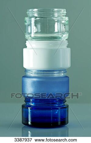 Stock Photo - Four cream jars on top of each other, close-up . Fotosearch