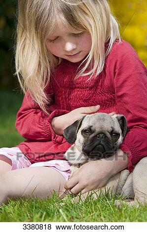 Stock Photo - Girl and pug on a meadow . Fotosearch