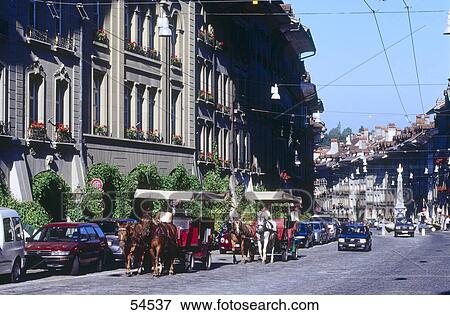 Stock Photo - Horse drawn carriages and cars on road, Berne, Switzerland . Fotosearch