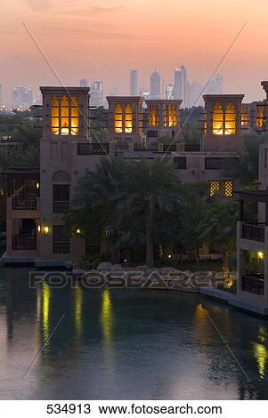 Stock Image - Hotel lit up at waterfront during dusk, Al Qasr Hotel, United Arab Emirates . Fotosearch