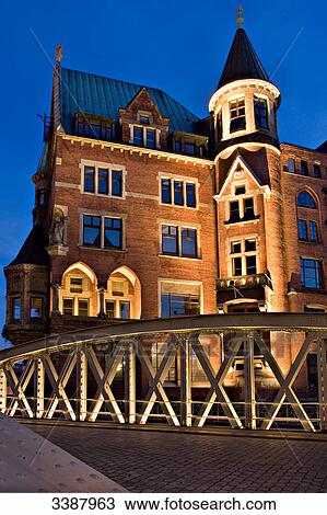 Stock Image - Illuminated building and bridge in the old warehouse district (Speicherstadt), Hamburg, Germany . Fotosearch