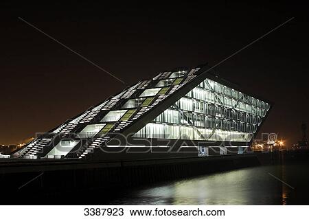 Stock Image - Illuminated office building on the riverbank at night, Hamburg, Germany . Fotosearch