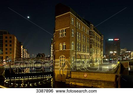 Stock Photograph - Illuminated old warehouse district (Speicherstadt) at night, Hamburg, Germany . Fotosearch