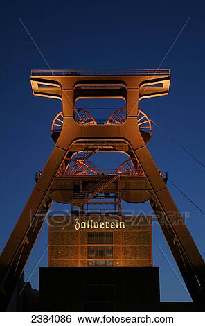 Stock Photograph - Industrial monument lit up at dusk, Zollverein Coal Mine Industrial Complex, Essen, North Rhine-Westphalia, Germany . Fotosearch