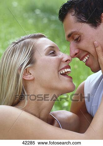 Stock Photography - Laughing couple facing each other . Fotosearch