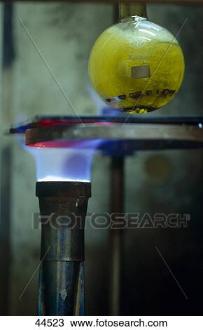 Stock Image - Liquid in flask over Bunsen burner . Fotosearch