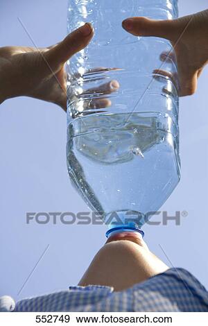 Stock Photo - Low angle close-up view of boy drinking water out of plastic bottle . Fotosearch