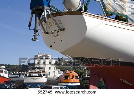 Stock Photography - Low angle view of yacht with castle in background, Dover Castle, Dover, Kent, England . Fotosearch