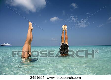 Stock Photography - Man and woman doing handstand in the water, Paradise Island, Bahamas . Fotosearch
