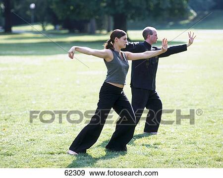 Stock Photo - Man and woman practicing tai chi . Fotosearch