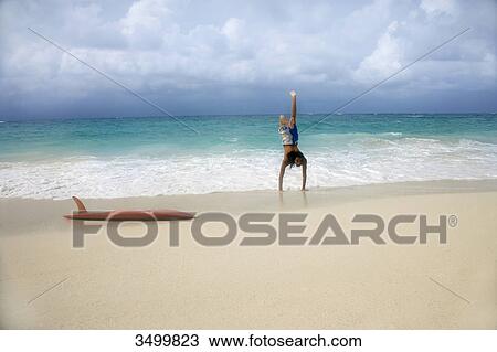 Stock Image - Man doing handstand on the beach, Paradise Island, Bahamas . Fotosearch