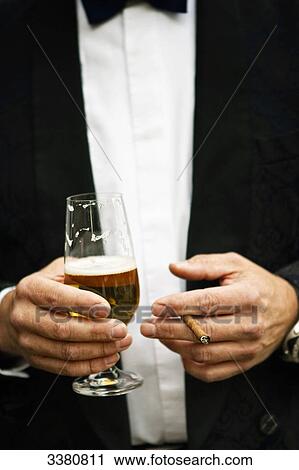 Man holding beer glass and small cigar, mid section View Large Photo Image Stock Image - Man holding beer glass and small cigar, mid section . Fotosearch