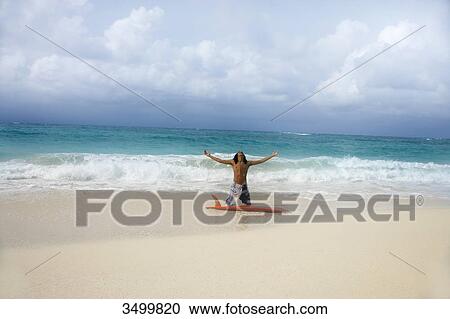 Man kneeling in front of a surfboard on the beach, Paradise Island, Bahamas View Large Photo Image Stock Image - Man kneeling in front of a surfboard on the beach, Paradise Island, Bahamas . Fotosearch