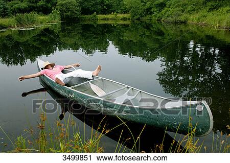 Man lying in a canoe with strawhat on his face, elevated view View Large Photo Image Stock Image - Man lying in a canoe with strawhat on his face, elevated view . Fotosearch