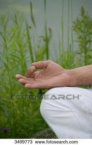 Stock Image - Man meditating in nature, detail . Fotosearch