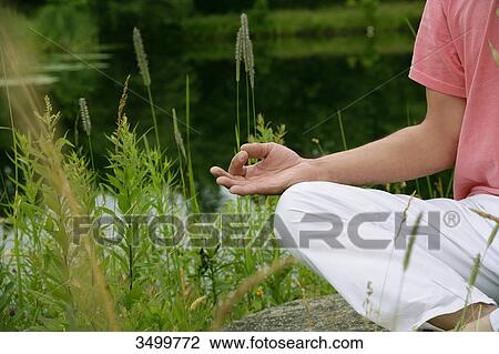 Stock Image - Man meditating in nature . Fotosearch