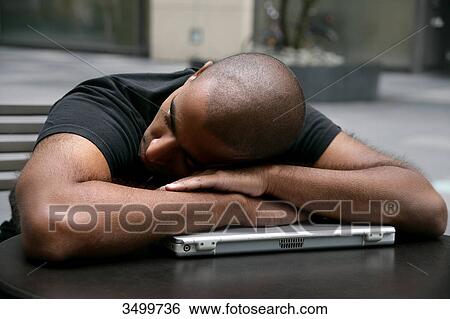 Stock Photograph - Man sleeping on a notebook . Fotosearch